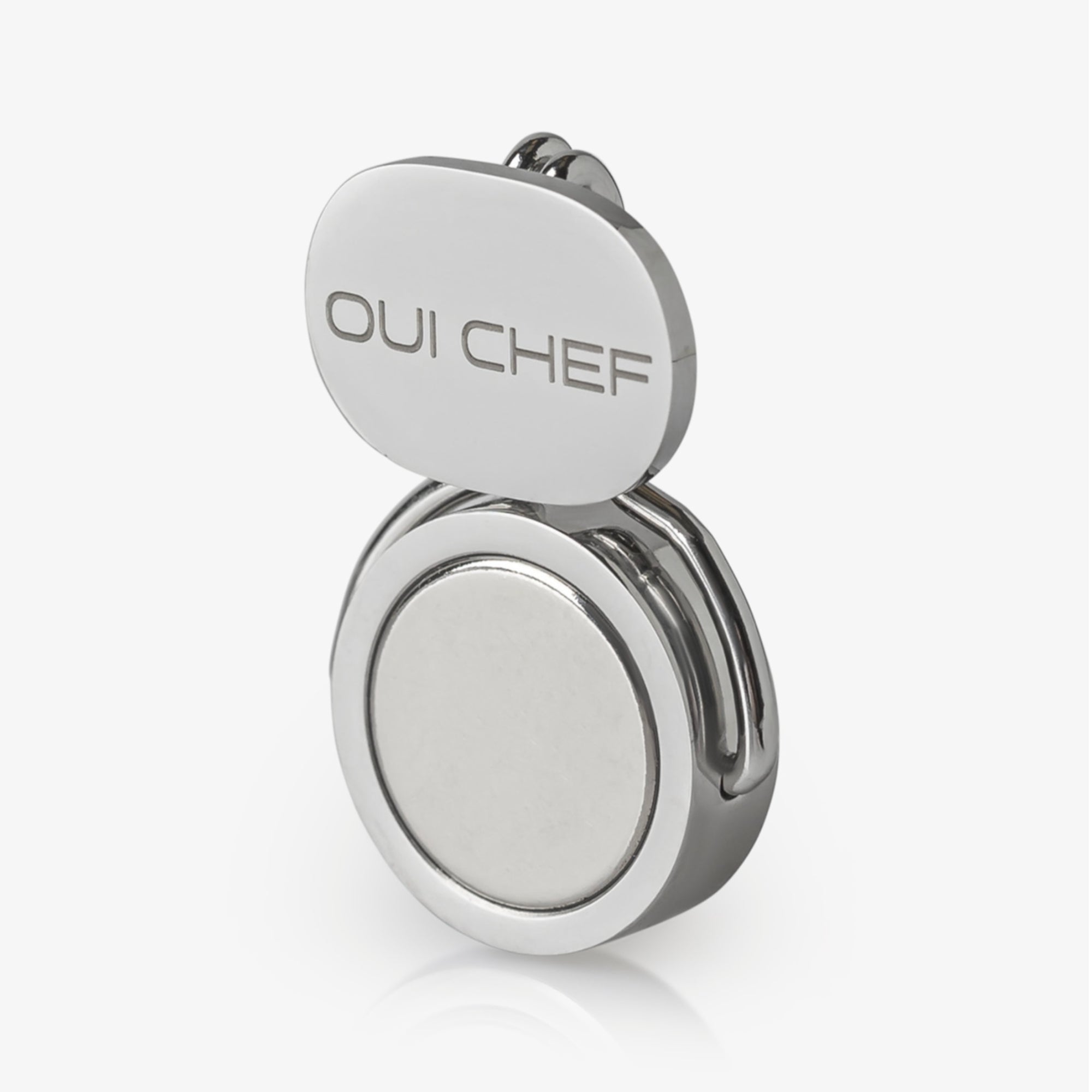 Stainless steel magnetic clip standing at an angle with 'OUI CHEF' branding on a white background